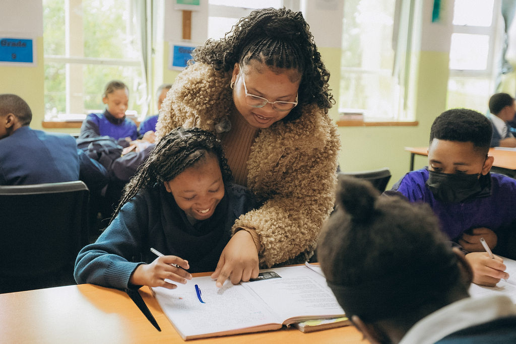Teacher guiding a learner with written work